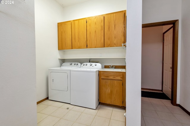 laundry area with washer and clothes dryer, cabinets, sink, and light tile patterned flooring