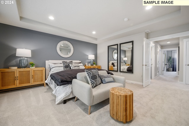 bedroom featuring light carpet and a tray ceiling