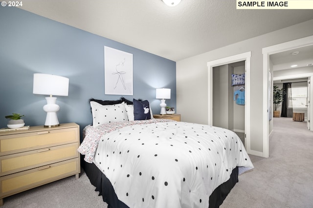 bedroom featuring light carpet and a textured ceiling