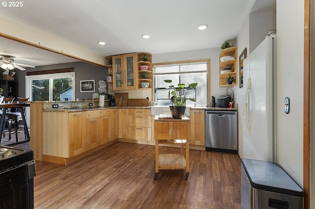 kitchen featuring a healthy amount of sunlight, dishwasher, dark stone counters, and light brown cabinets