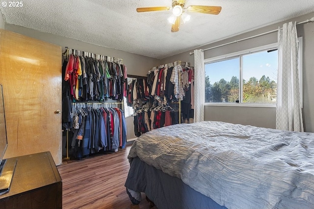 bedroom with a closet, a textured ceiling, hardwood / wood-style flooring, and ceiling fan