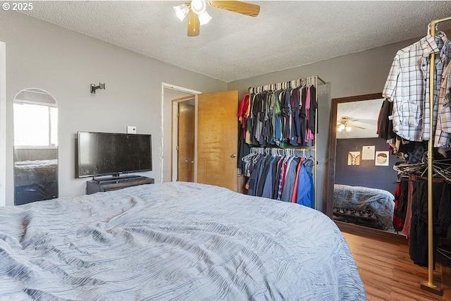 bedroom featuring hardwood / wood-style flooring, ceiling fan, a textured ceiling, and a closet