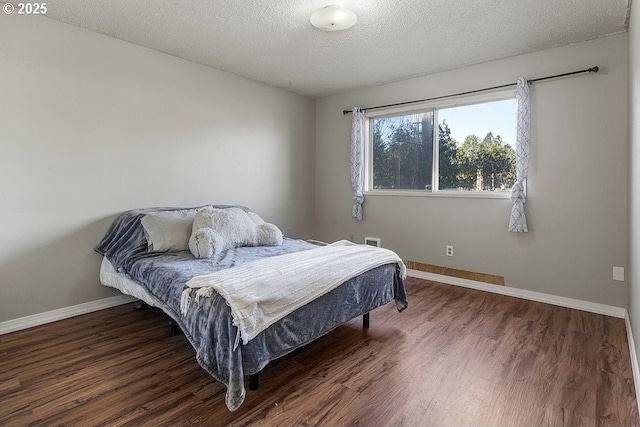 bedroom featuring dark hardwood / wood-style floors and a textured ceiling