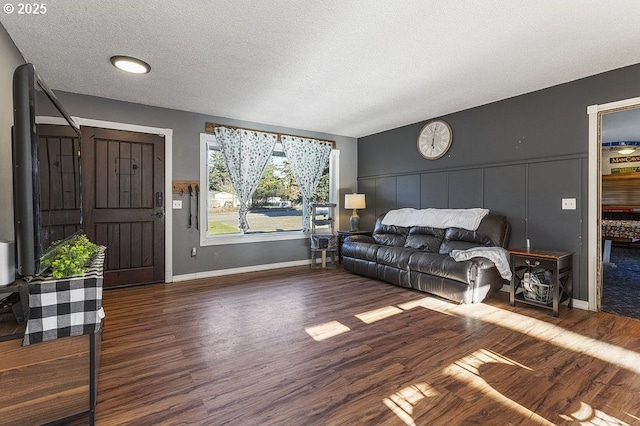 living room featuring a textured ceiling and dark hardwood / wood-style floors