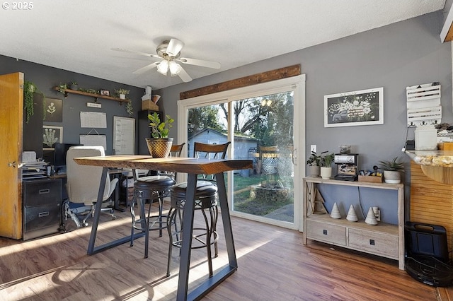 dining space with hardwood / wood-style floors, a textured ceiling, and ceiling fan