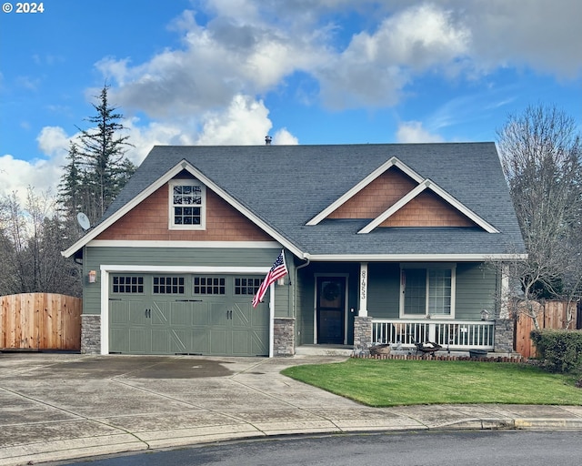 craftsman-style home with a front lawn, covered porch, and a garage