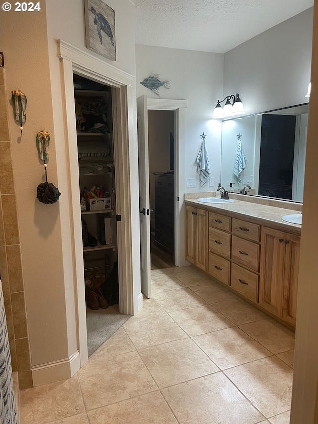 bathroom featuring tile patterned flooring, vanity, and a textured ceiling