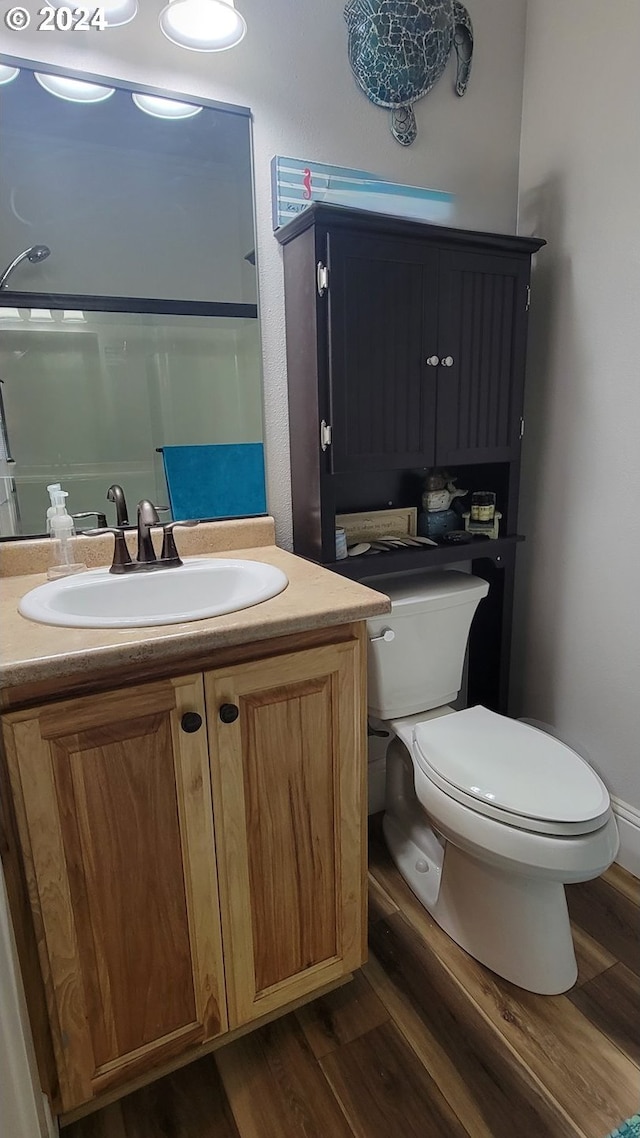 bathroom with hardwood / wood-style flooring, vanity, and toilet