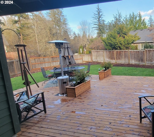 wooden terrace featuring a lawn