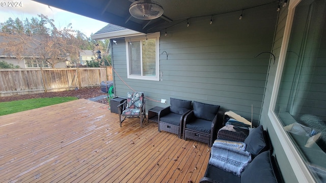 wooden terrace featuring ceiling fan and an outdoor living space