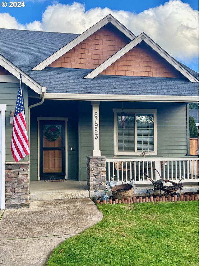 doorway to property featuring a porch and a yard