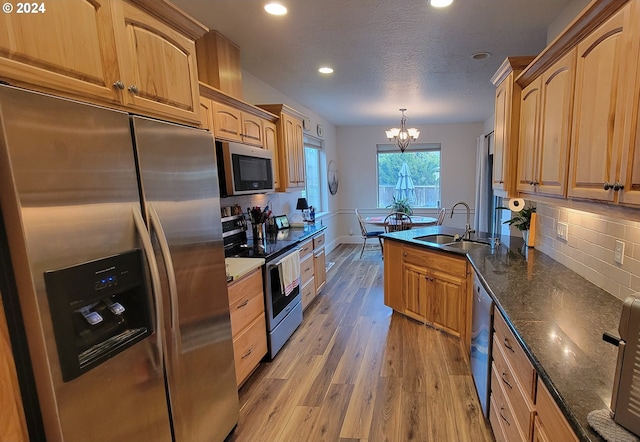 kitchen with an inviting chandelier, sink, hanging light fixtures, light hardwood / wood-style flooring, and stainless steel appliances