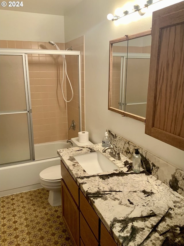 bathroom with shower / bath combination with glass door, vanity, and toilet