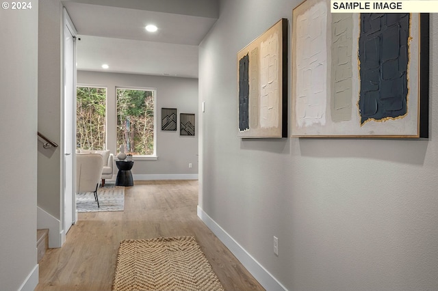 corridor featuring electric panel and light hardwood / wood-style floors