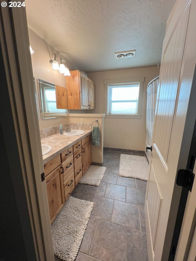 bathroom with vanity and a textured ceiling