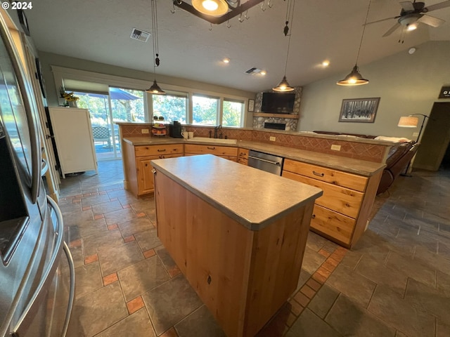 kitchen featuring ceiling fan, a center island, stainless steel appliances, and vaulted ceiling