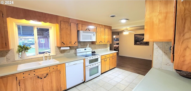 kitchen featuring tasteful backsplash, white appliances, ceiling fan, sink, and light hardwood / wood-style floors