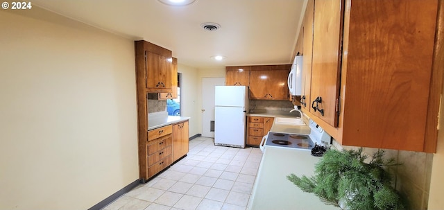 kitchen with white appliances, tasteful backsplash, and sink