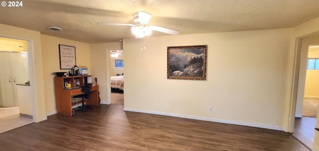 interior space with a textured ceiling, ceiling fan, and dark hardwood / wood-style floors