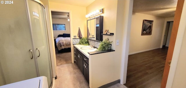 bathroom with hardwood / wood-style floors, vanity, ceiling fan, and a shower with shower door