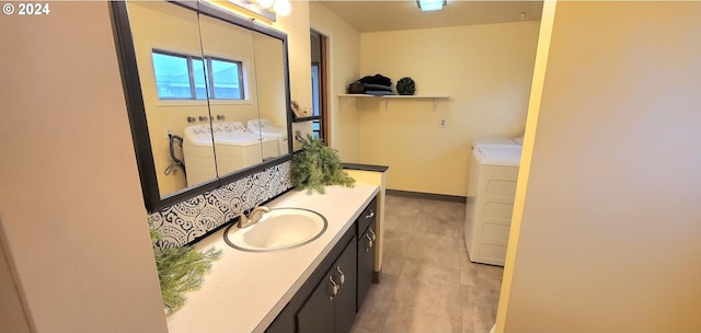 bathroom with washing machine and clothes dryer and sink