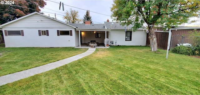 rear view of house with a lawn and a patio