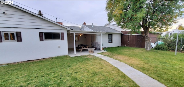 rear view of property with a yard and a patio