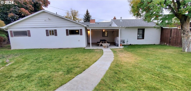 back of property featuring a yard and a patio area