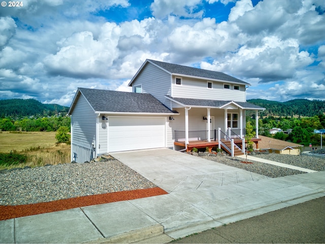 view of front facade with a porch, a mountain view, and a garage