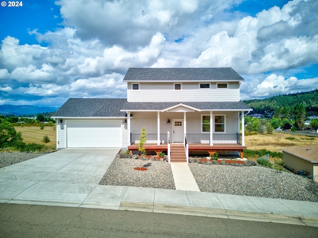 view of front of property featuring covered porch, a mountain view, and a garage