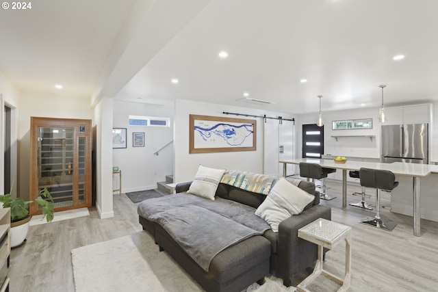 living room featuring light wood-type flooring and a barn door