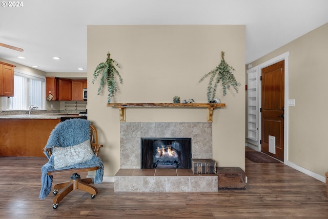 living room featuring hardwood / wood-style floors and a tiled fireplace