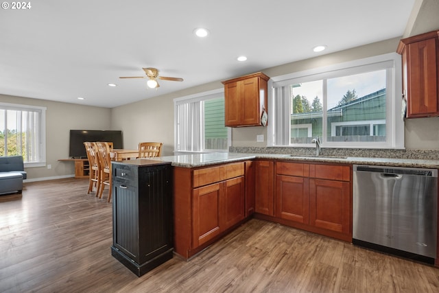 kitchen featuring ceiling fan, stainless steel dishwasher, sink, kitchen peninsula, and light hardwood / wood-style flooring