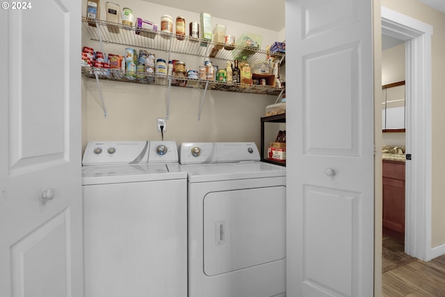 laundry room with light hardwood / wood-style flooring, sink, and washing machine and dryer