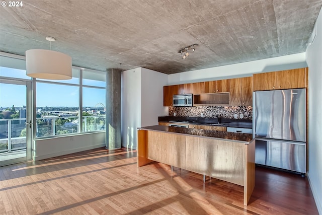 kitchen with stainless steel appliances, backsplash, dark wood-type flooring, and hanging light fixtures