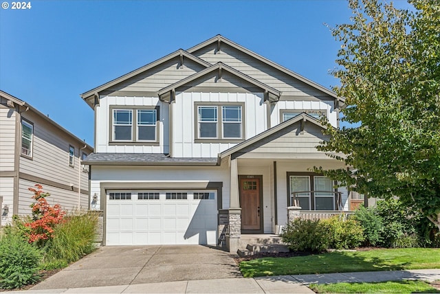 craftsman-style home featuring covered porch, a garage, and a front lawn