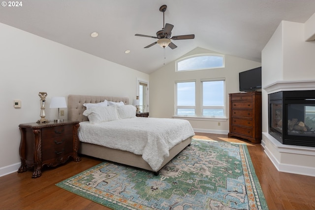 bedroom with ceiling fan, high vaulted ceiling, hardwood / wood-style floors, and a multi sided fireplace