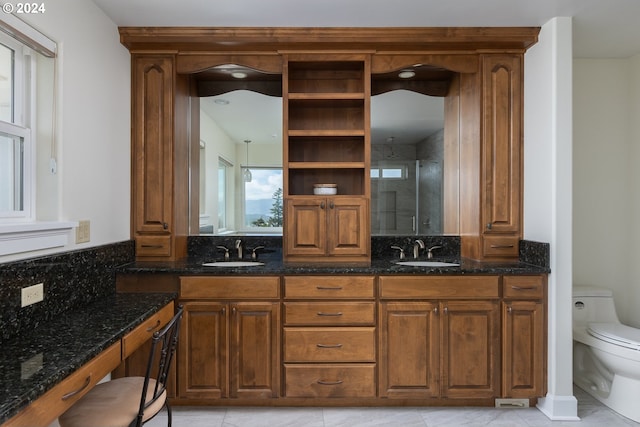 kitchen featuring brown cabinets, a sink, dark stone countertops, and open shelves