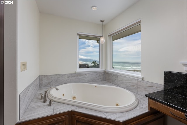 bathroom featuring tiled bath and a water view