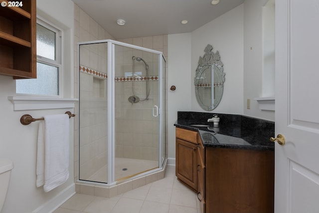 bathroom with toilet, tile patterned floors, a shower with door, and vanity