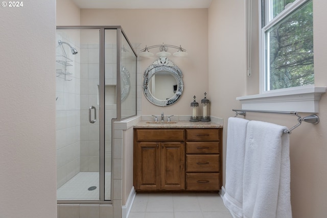 bathroom featuring tile patterned floors, a shower with door, and vanity