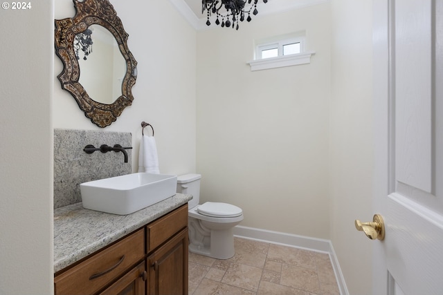 bathroom with an inviting chandelier, vanity, tile patterned flooring, crown molding, and toilet