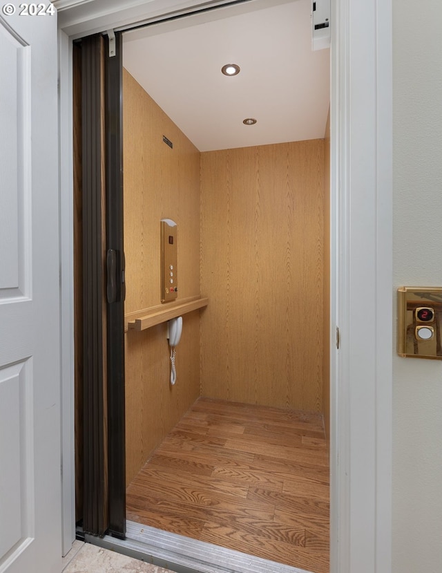 interior space featuring elevator and wooden walls