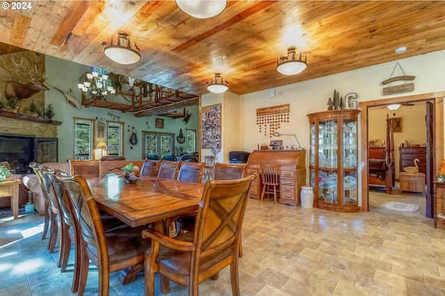 dining room with tile flooring, ceiling fan, a fireplace, and wood ceiling