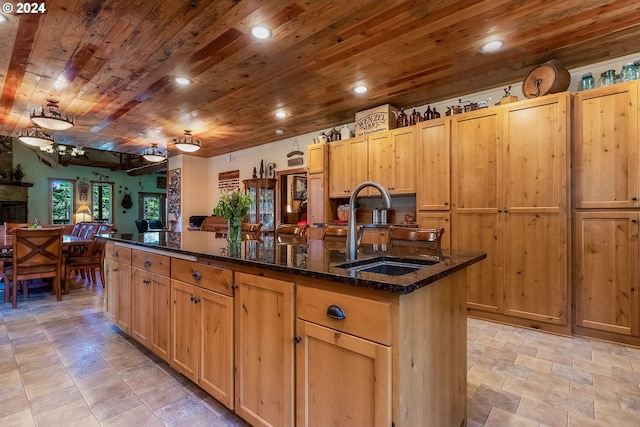 kitchen with sink, light tile floors, dark stone counters, and wooden ceiling