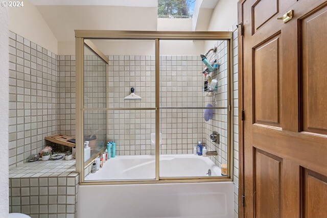 bathroom featuring combined bath / shower with glass door