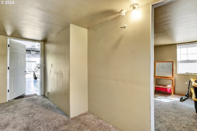 corridor with a textured ceiling and carpet