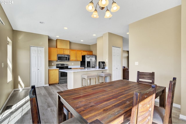 dining space featuring light hardwood / wood-style floors and a chandelier