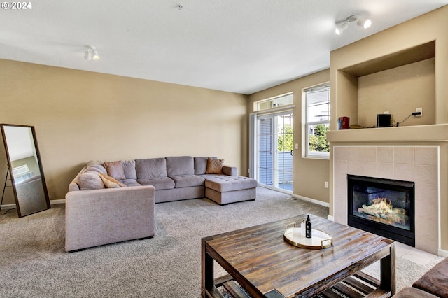 carpeted living room with a textured ceiling and a tiled fireplace