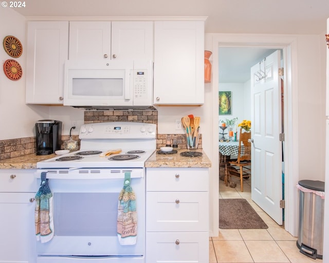 kitchen with light stone counters, white appliances, white cabinets, and light tile floors